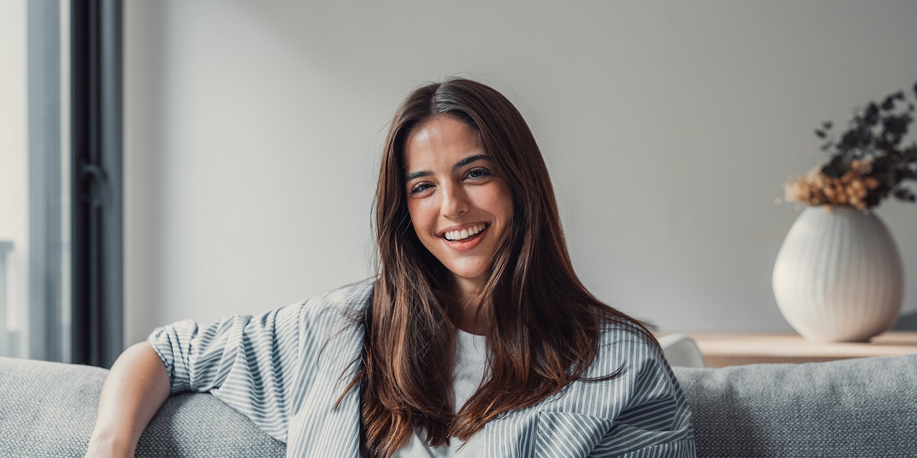 Woman smiling while sitting on sofa