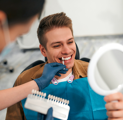 Patient examining veneers in mirror