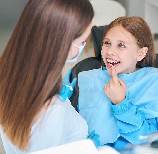 Dentist examining child with broken tooth