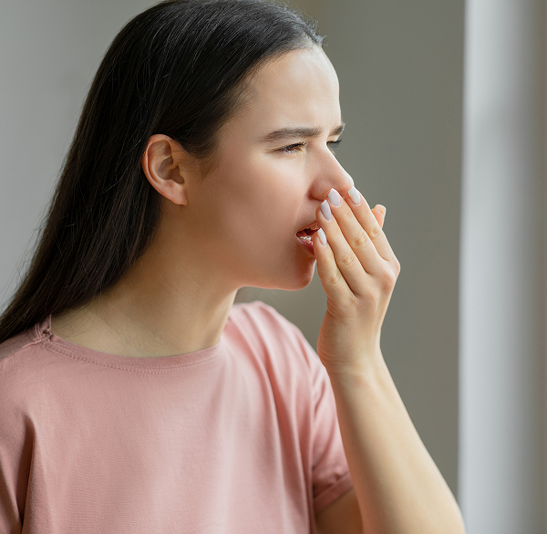 Woman covering mouth due to bad breath